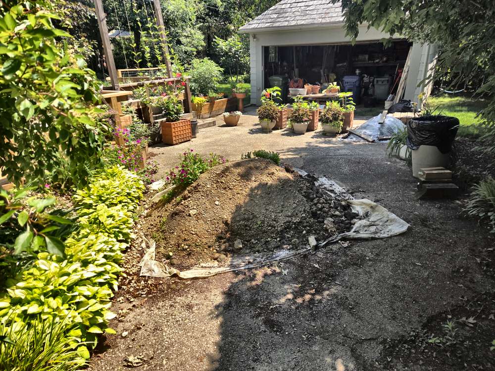 Large mound of soil covering a gravel driveway before dirt pile removal in Davidsonville, MD