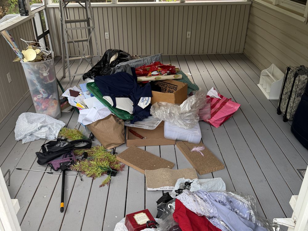 Screened porch packed with boxes, bags, and household items before an estate cleanout in Davidsonville, MD