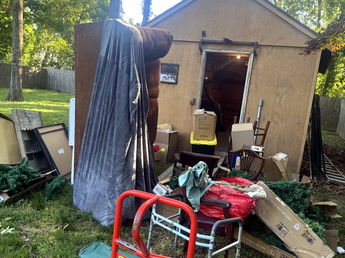 Backyard shed and piled yard debris at a Gambrills home off Braun Avenue before a shed cleanout