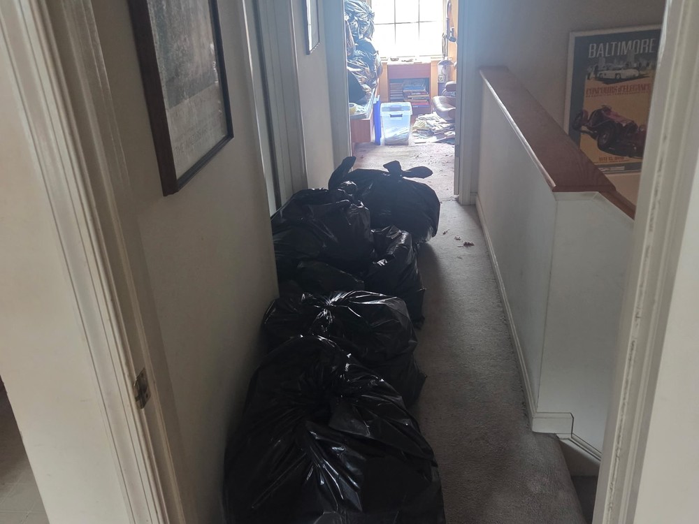 Upstairs hallway lined with bagged belongings before the whole-house estate cleanout on Icy Run Terrace, Odenton, MD